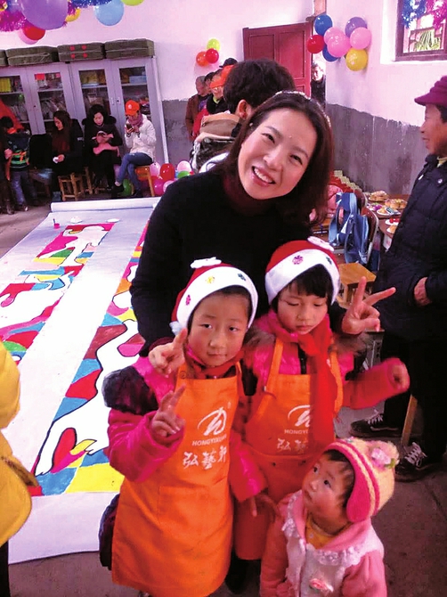 　　唐红梅与小微企业负责人一道赴龙门村小陪留守儿童过新年。
